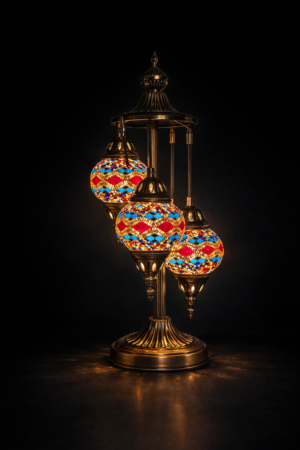 Lampe mosaïque artisanale à trois globes colorés, posée sur table, diffusant une lumière chaleureuse et décorative dans un intérieur élégant
