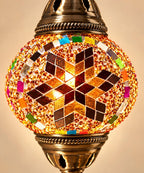 Gros plan sur le globe en verre d'une lampe mosaïque multicolore