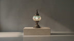 Lampe mosaïque artisanale turquoise et blanche, création faite main posée sur socle en pierre, éclairage doux, décoration intérieure haut de gamme.