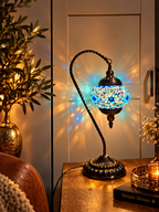 Lampe mosaïque Cygne Bleu allumée sur une table dans un salon élégant aux tons beige et bleu