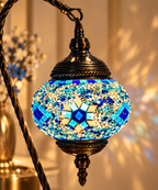 Gros plan sur le globe de la lampe mosaïque Cygne Bleu aux motifs bleus, turquoise et dorés