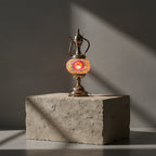 Lampe théière mosaïque allumée – éclairage oriental artisanal fait main Lampe théière mosaïque orange – socle béton fond clair – Mosaic Dream